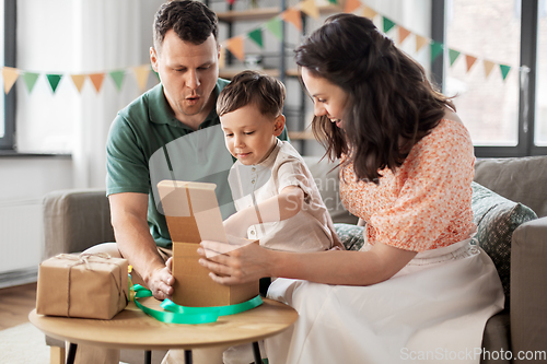 Image of happy family opening birthday presents at home