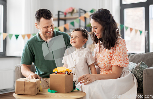 Image of happy family opening birthday presents at home