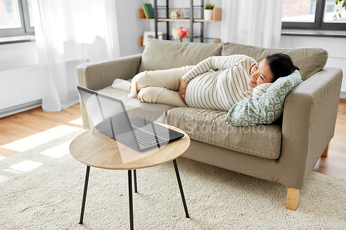 Image of happy pregnant asian woman with laptop at home