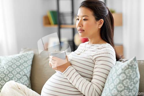 Image of pregnant woman drinking tea at home