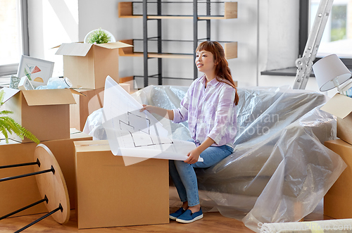 Image of woman with blueprint and boxes moving to new home