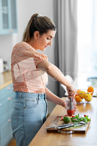 Image of woman making cocktail drinks at home kitchen