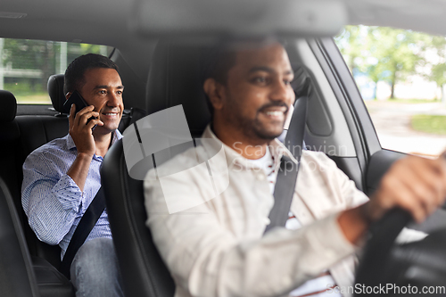 Image of male passenger calling on smartphone in taxi car