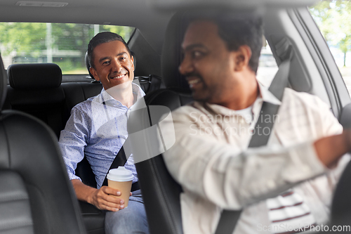 Image of male passenger with coffee talking to car driver