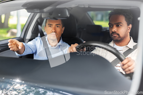 Image of car driving school instructor teaching male driver