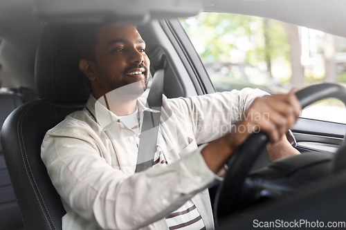 Image of smiling indian man or driver driving car