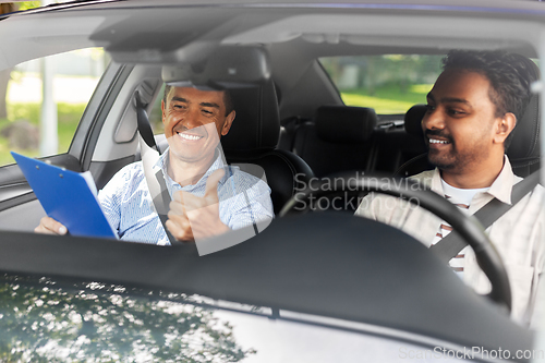 Image of smiling car driving school instructor and driver