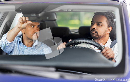 Image of car driving school instructor teaching male driver