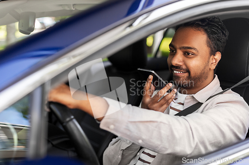 Image of man driving car and recording voice by smartphone