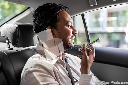 Image of male passenger calling on smartphone in taxi car