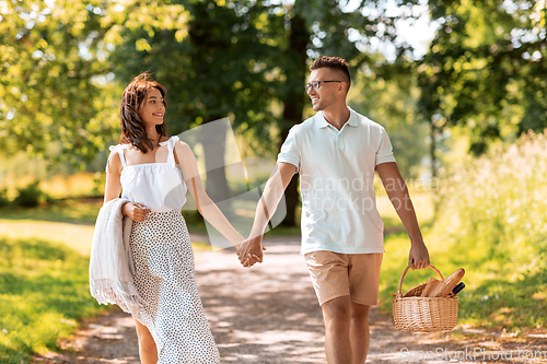 Image of happy couple with picnic basket at summer park