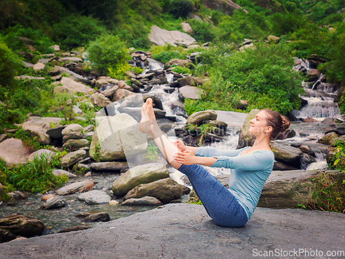 Image of Woman doing Ashtanga Vinyasa Yoga asana Navasana - boat pose