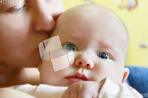 Image of mother kisses her little daughter