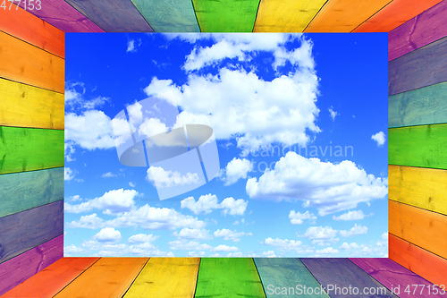 Image of multicilored frame on the cloudy blue sky background