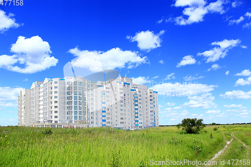 Image of multistory modern blocks of flat in field with grass