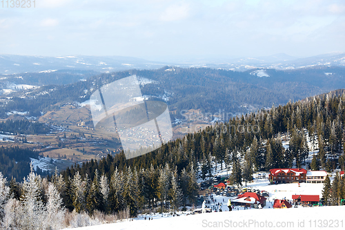 Image of Beautiful colorful landscape. The ski resort with a background of a small residential area surrounded by trees.