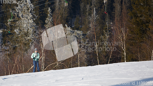 Image of Happy young woman on button ski lift going uphill