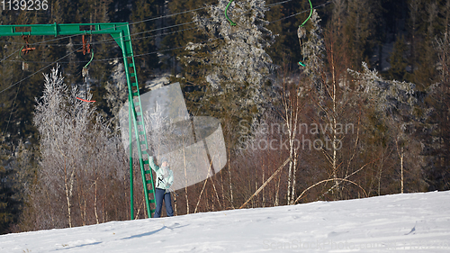 Image of Happy young woman on button ski lift going uphill