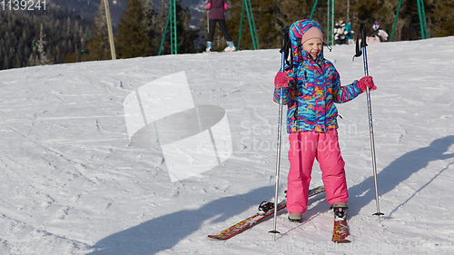 Image of A happy little girl off skiing with slides