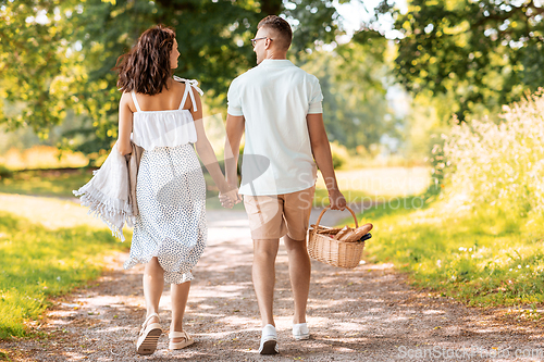 Image of happy couple with picnic basket at summer park