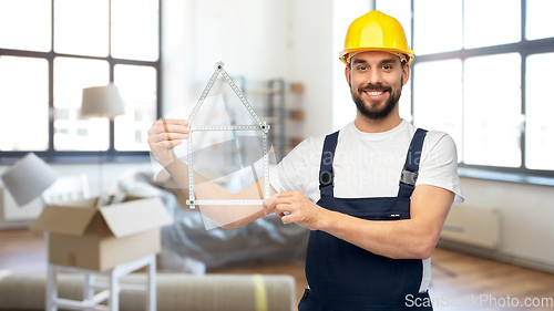 Image of happy male builder with carpenter's rule at home