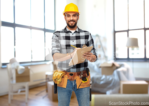 Image of male builder in helmet with clipboard at home