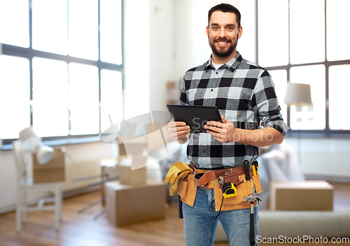 Image of happy builder with tablet pc and tools at home