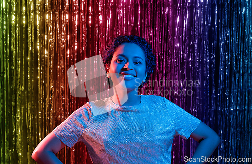 Image of african woman at party over rainbow curtain