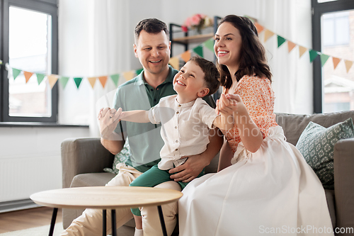 Image of happy family with little son at birthday party