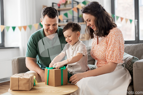 Image of happy family opening birthday presents at home