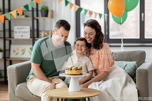 Image of happy family with birthday cake at home