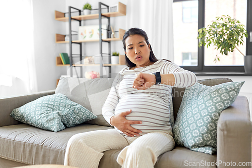 Image of pregnant woman having labor contractions at home