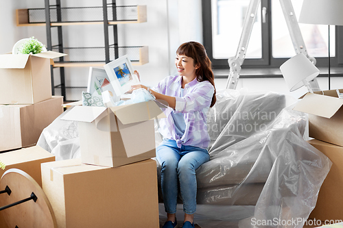 Image of happy woman unpacking boxes and moving to new home