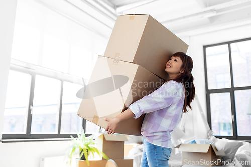 Image of happy woman holding boxes and moving to new home