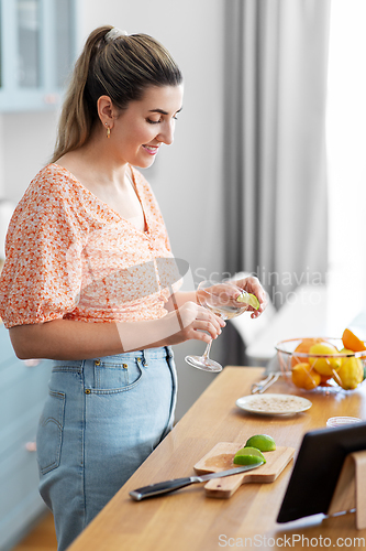 Image of woman making cocktail drinks at home kitchen