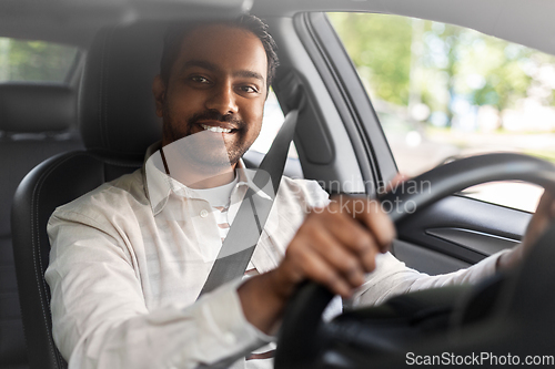 Image of smiling indian man or driver driving car