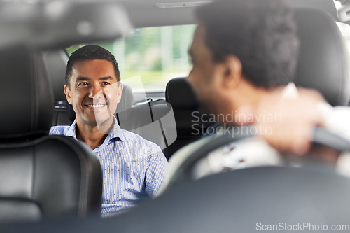 Image of middle aged male passenger talking to car driver