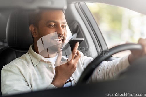 Image of man driving car and recording voice by smartphone