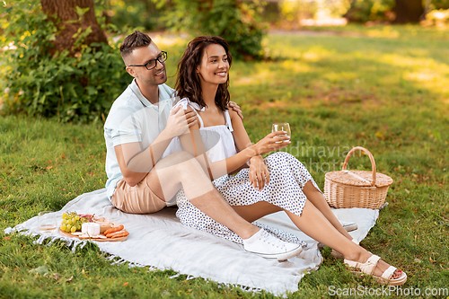 Image of happy couple having picnic at summer park