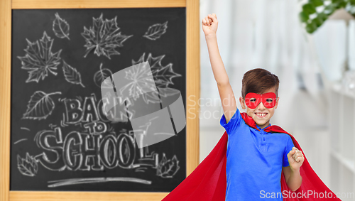 Image of boy in super hero costume over school blackboard