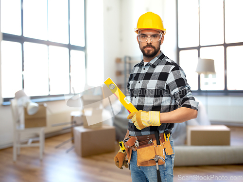 Image of male builder in helmet with level at home