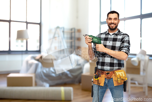 Image of happy male builder with drill and tools at home