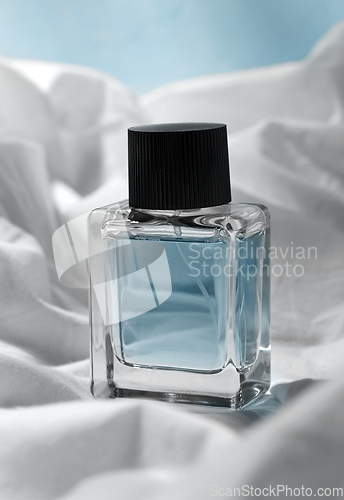 Image of bottle of perfume on white sheet