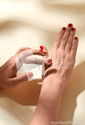 Image of close up of hands applying natural scrub to skin