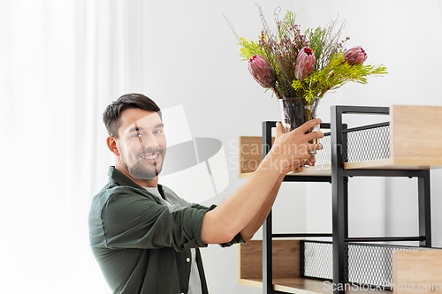 Image of man decorating home with flower or houseplant