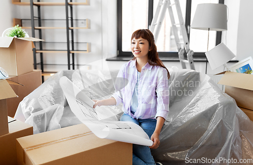 Image of woman with blueprint and boxes moving to new home