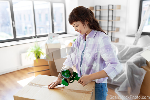 Image of woman with adhesive tape packing box at new home