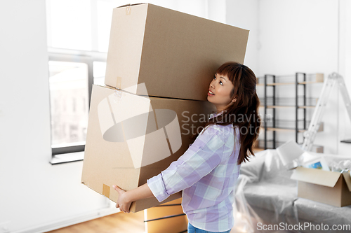 Image of happy woman holding boxes and moving to new home