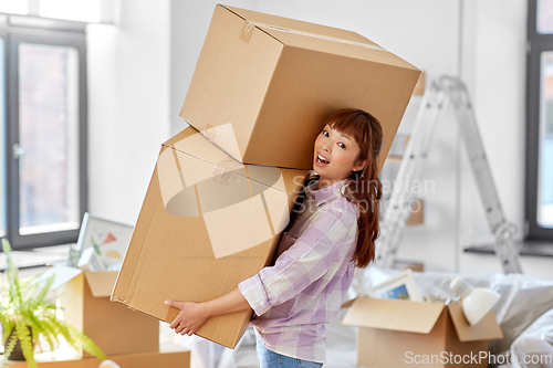 Image of happy woman holding boxes and moving to new home