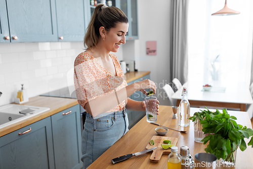 Image of woman making cocktail drinks at home kitchen